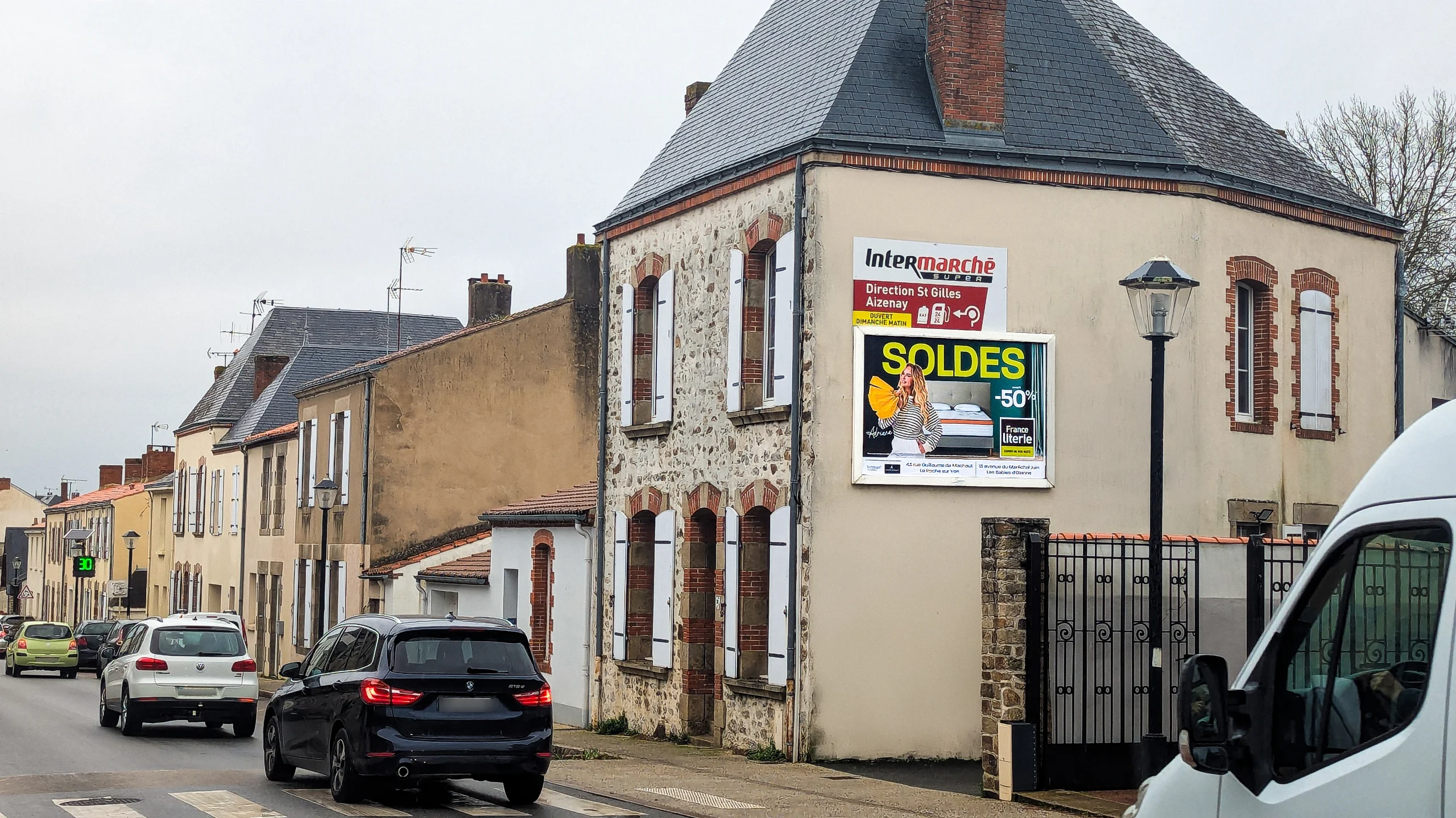 Affiche extérieure « SOLDES –50 % France Literie » installée sur la façade d’un immeuble urbain à La Roche-sur-Yon (Vendée), dans le cadre d’une campagne d’affichage orchestrée par Sodicos
