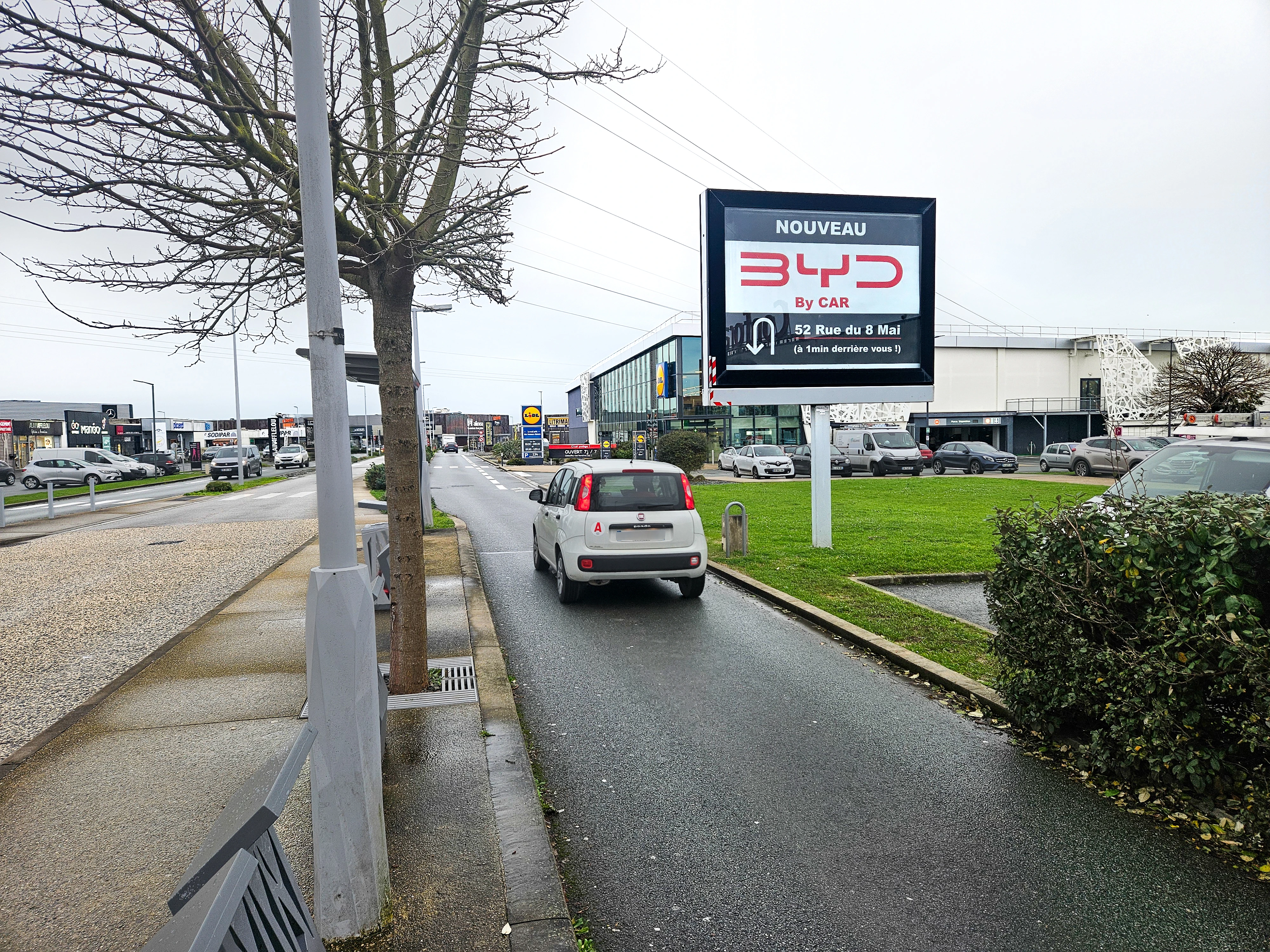 Panneau publicitaire dynamique déroulant diffusant une campagne d’affichage temporaire dans une zone commerciale