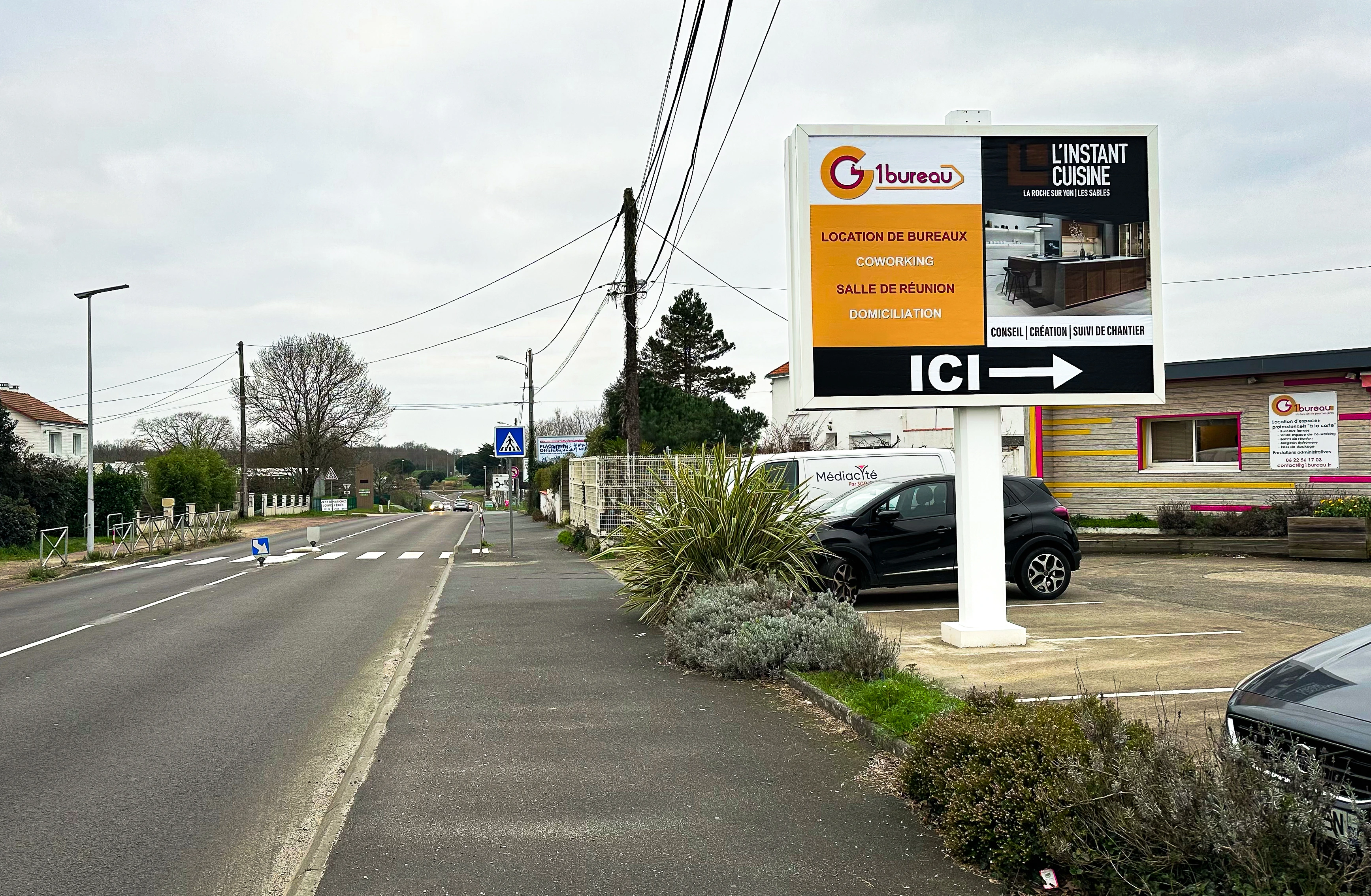 Panneau publicitaire directionnel installé en bord de route à La Roche-sur-Yon indiquant l’emplacement d’une entreprise aux automobilistes.
