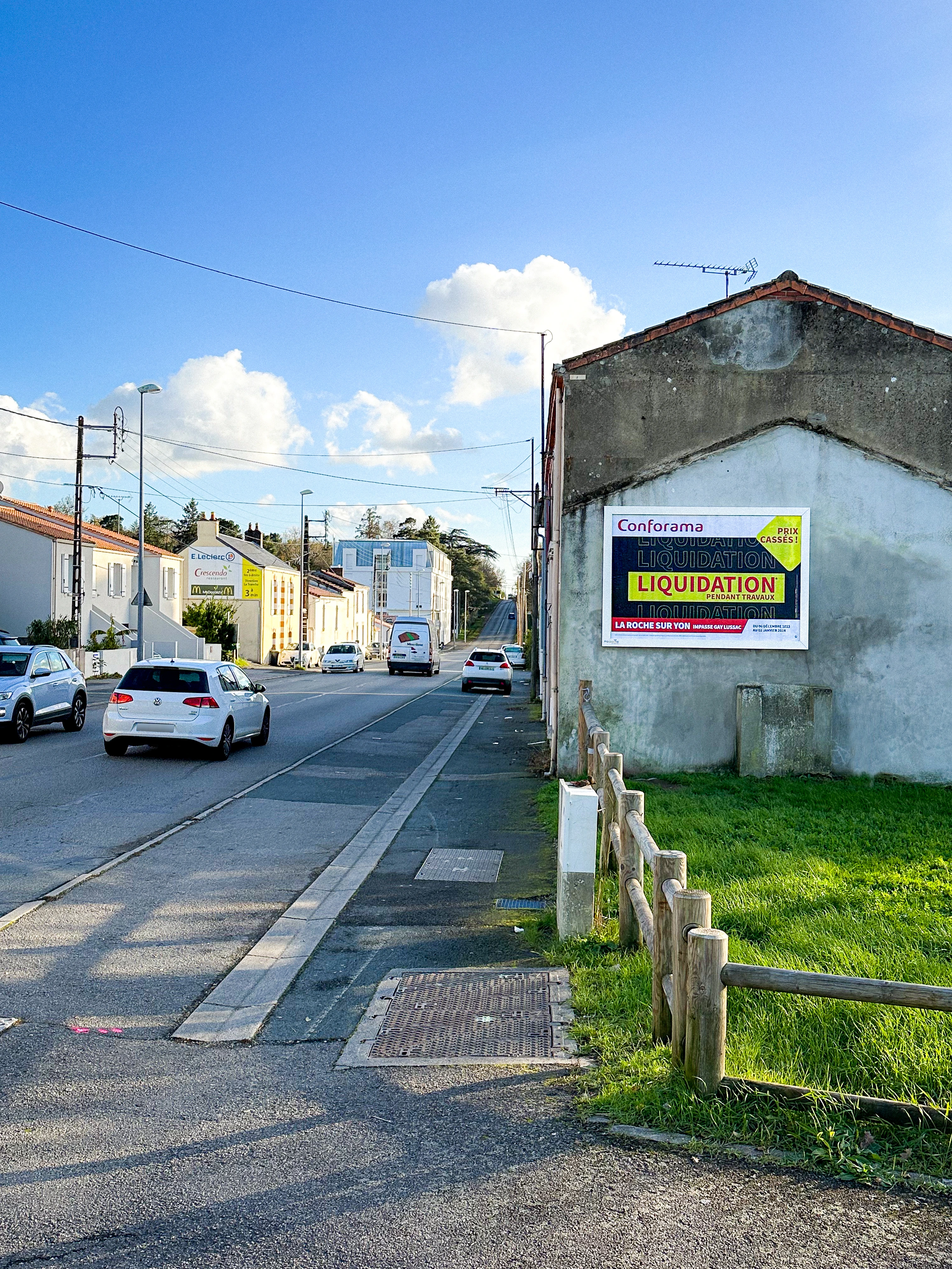 Panneau publicitaire mural installé sur la façade d’un bâtiment en bord de route à La Roche-sur-Yon visible par les automobilistes.