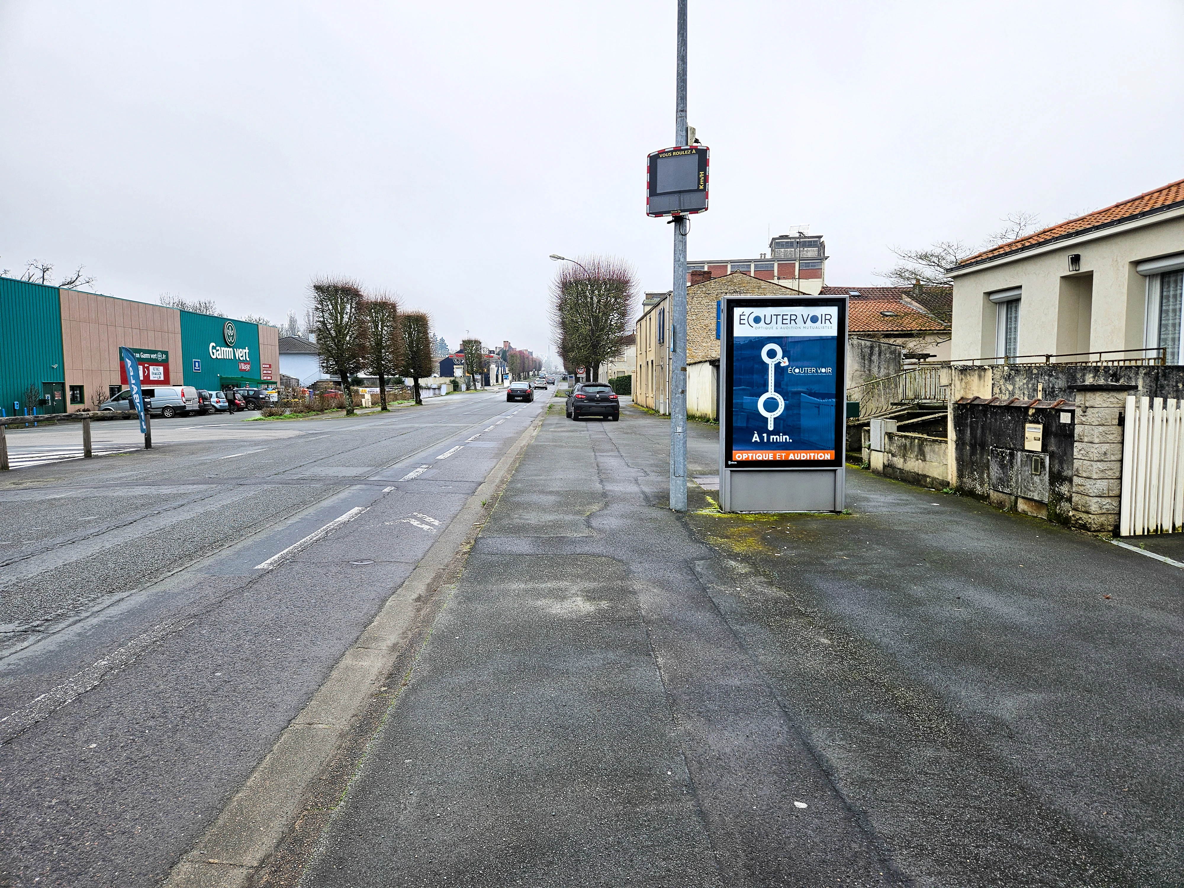 Panneau publicitaire urbain installé en bord de route à La Roche-sur-Yon pour orienter les automobilistes vers un commerce local.