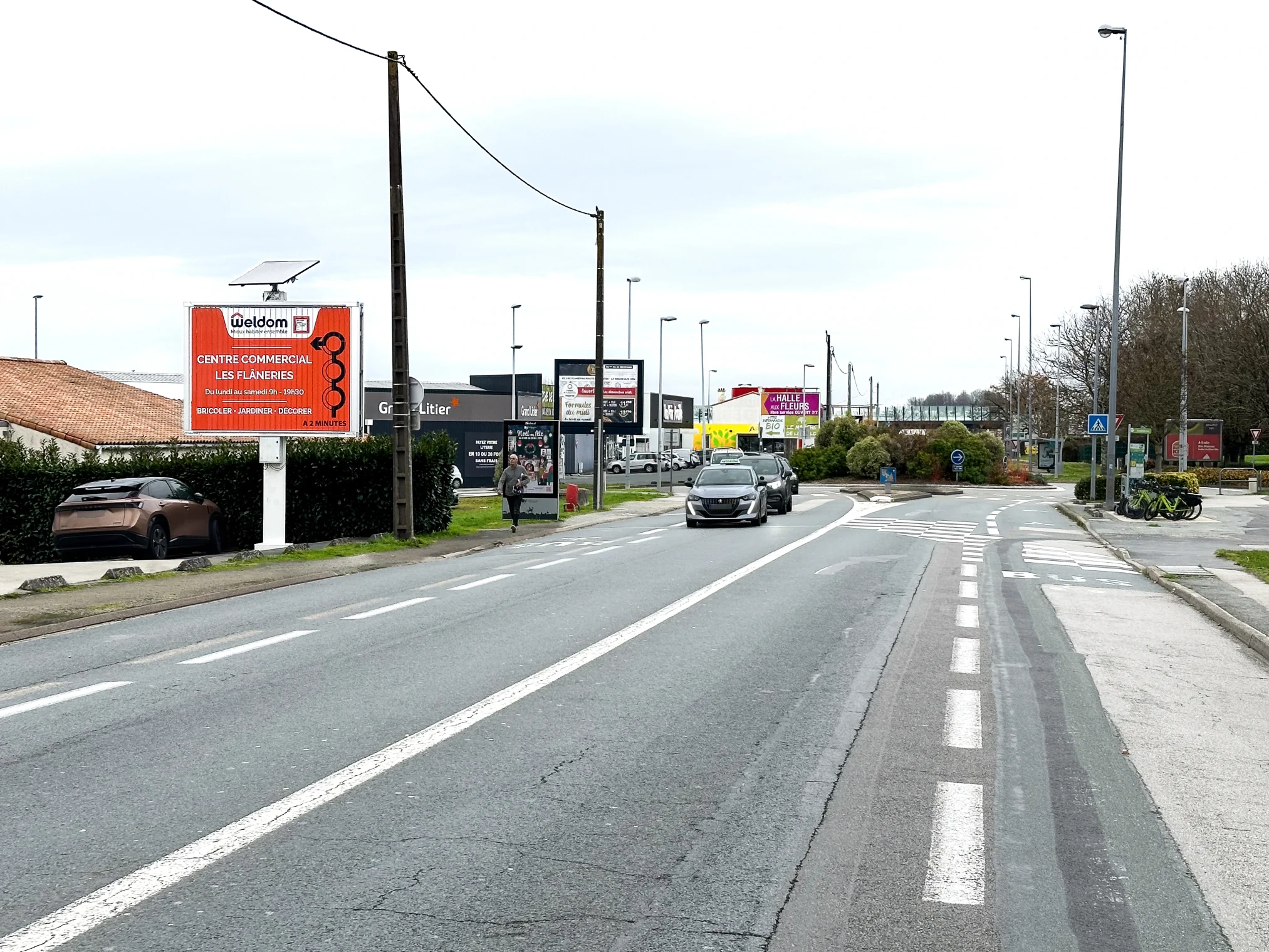 Panneau publicitaire installé sur un axe routier menant à la zone commerciale Les Flâneries à La Roche-sur-Yon.