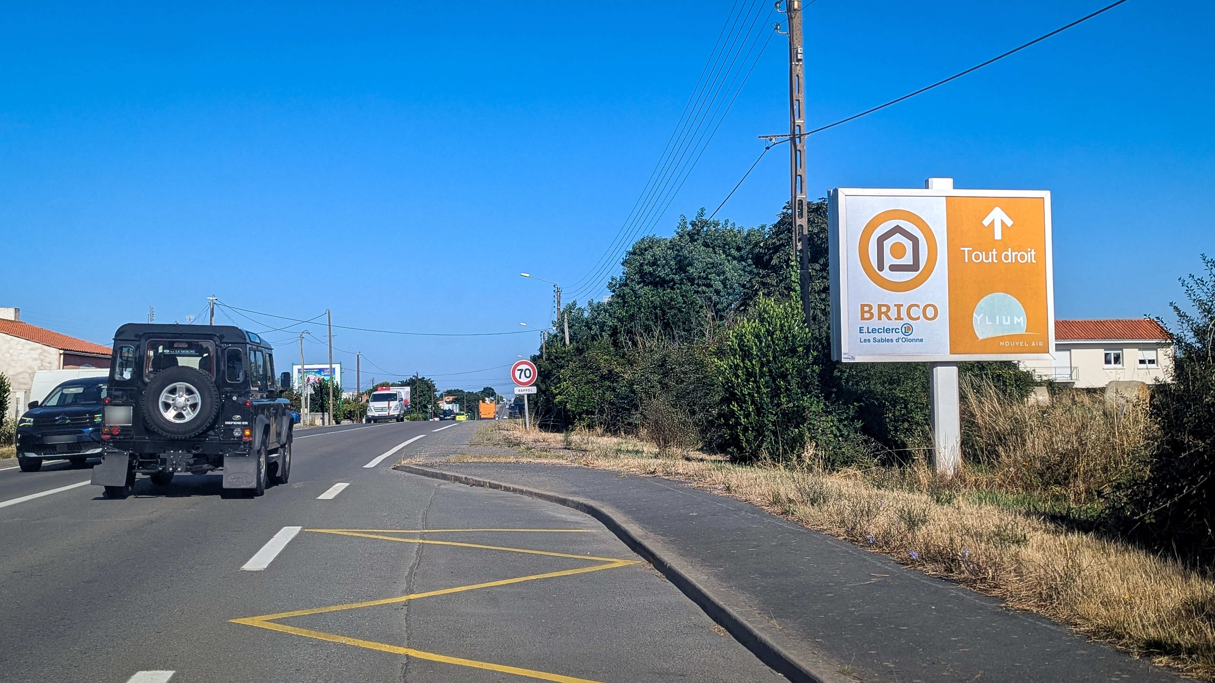 Panneau publicitaire directionnel Brico Leclerc visible sur un axe routier aux Sables d’Olonne