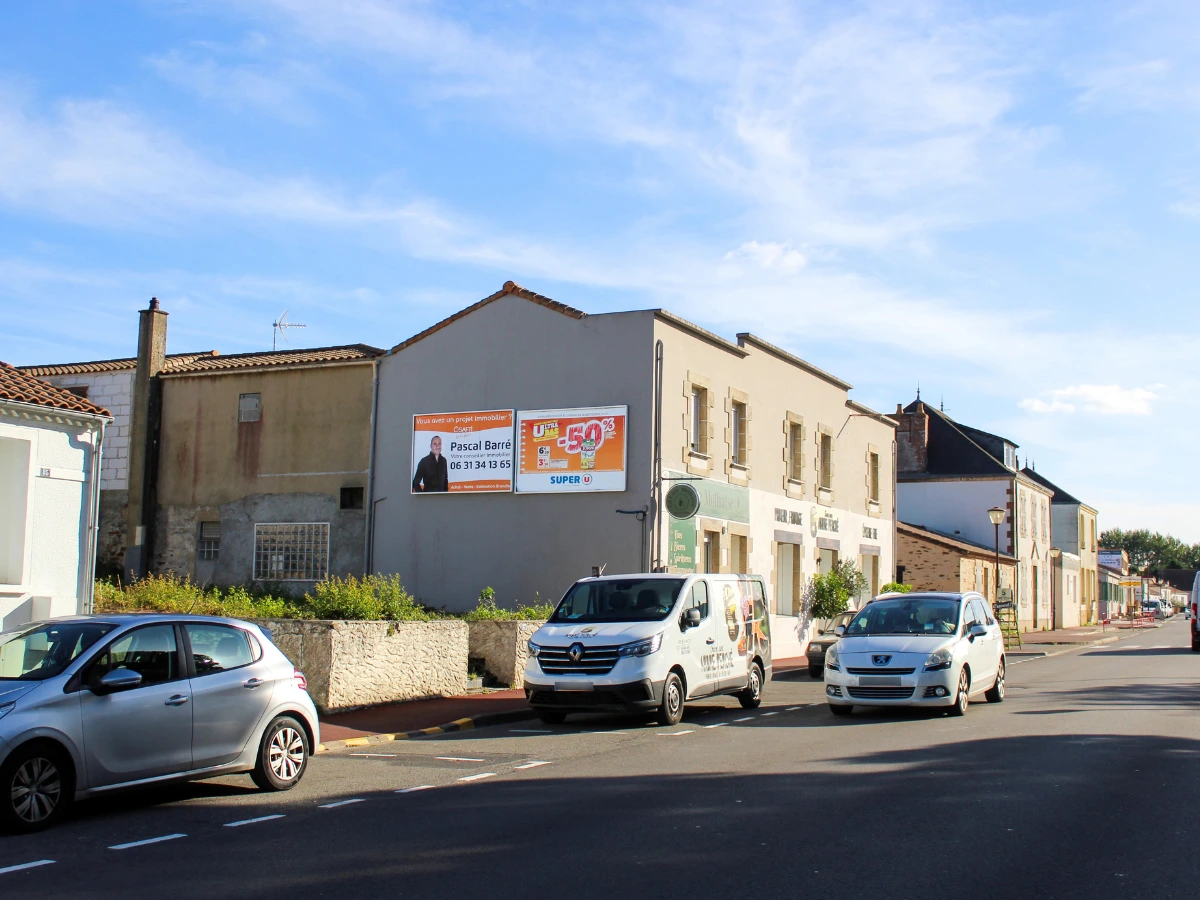 Panneau d’affichage publicitaire sur mesure installé sur un mur en centre-ville pour une campagne de communication locale en Vendée.