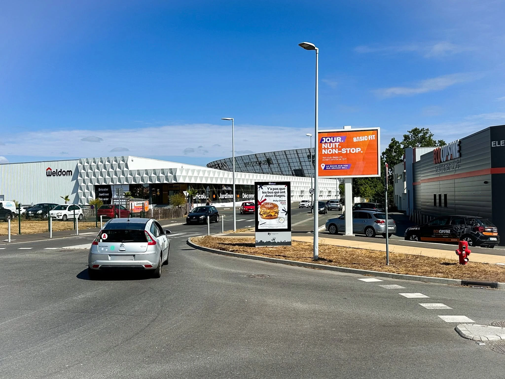 Panneaux publicitaires extérieurs dans une zone commerciale à La Roche-sur-Yon, près des enseignes Weldom et Eco Cuisine.
